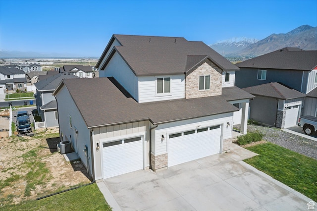 1147 N Carriage Ln, Spanish Fork, UT 84660 - view of front of house with board and batten siding, roof with shingles, central air condition unit, concrete driveway, and stone siding