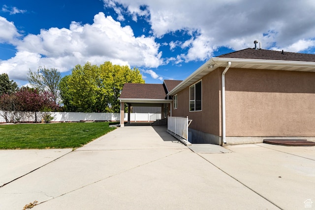 4902 W Pine Laurel Ln, West Jordan, UT 84081 - view of home's exterior with a lawn, fence, stucco siding, and a carport