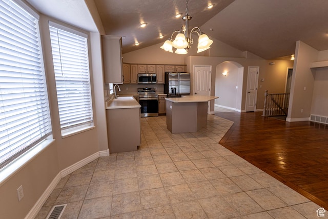 4902 W Pine Laurel Ln, West Jordan, UT 84081 - kitchen with visible vents, arched walkways, a center island, light countertops, and stainless steel appliances