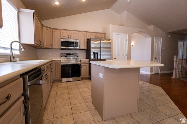4902 W Pine Laurel Ln, West Jordan, UT 84081 - kitchen featuring appliances with stainless steel finishes, a sink, arched walkways, lofted ceiling, and a kitchen island