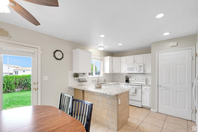kitchen with white appliances, a peninsula, a sink, and backsplash