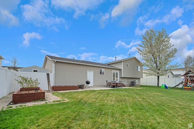 back of property with a patio, a fenced backyard, a vegetable garden, a playground, and a yard