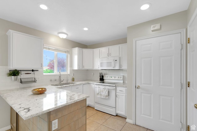 kitchen with light stone countertops, a sink, white appliances, a peninsula, and backsplash