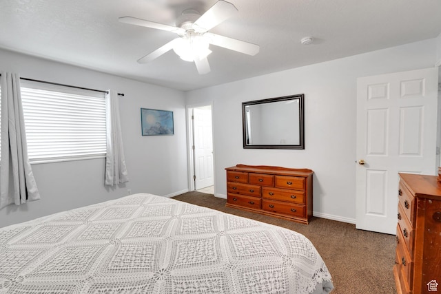 bedroom featuring dark colored carpet, a ceiling fan, and baseboards