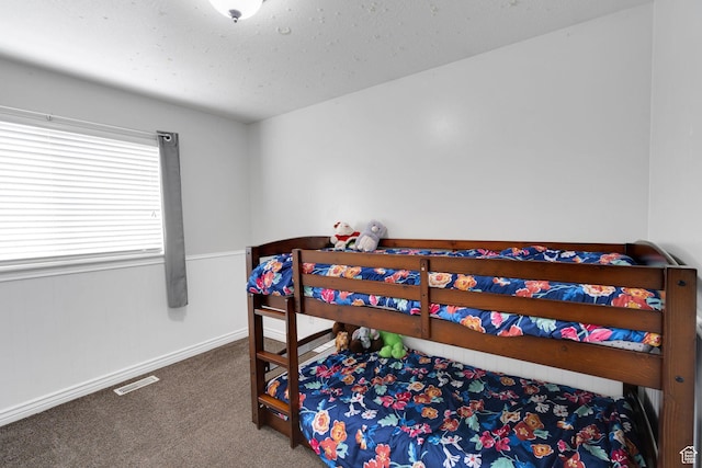 carpeted bedroom featuring baseboards and visible vents