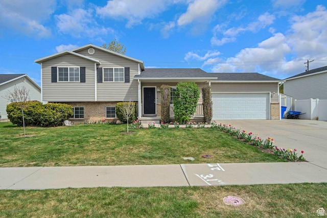 split level home featuring brick siding, an attached garage, a front yard, and concrete driveway