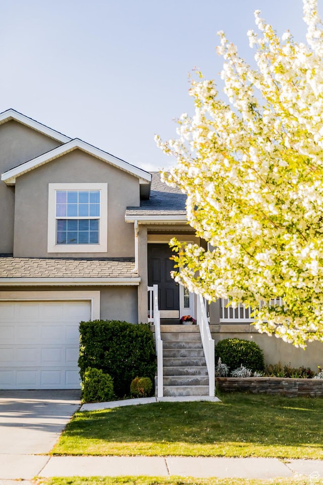 4866 W Spirit Lake Cir, Riverton, UT 84096 - view of front of home featuring a garage, a front lawn, stucco siding, and driveway