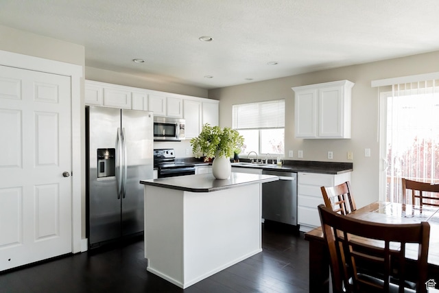 4866 W Spirit Lake Cir, Riverton, UT 84096 - kitchen featuring white cabinets, stainless steel appliances, dark countertops, and a wealth of natural light