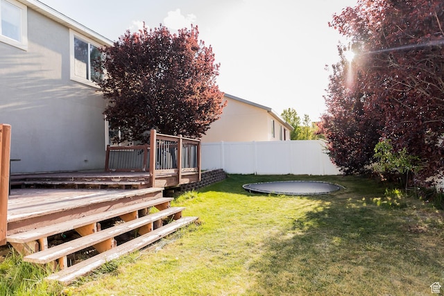 4866 W Spirit Lake Cir, Riverton, UT 84096 - view of yard featuring fence, a wooden deck, and a trampoline