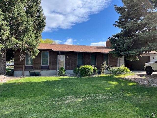 ranch-style home with a front lawn, brick siding, and an attached garage