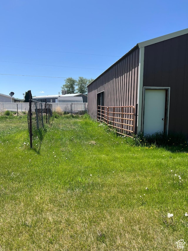 view of yard featuring fence and an outbuilding