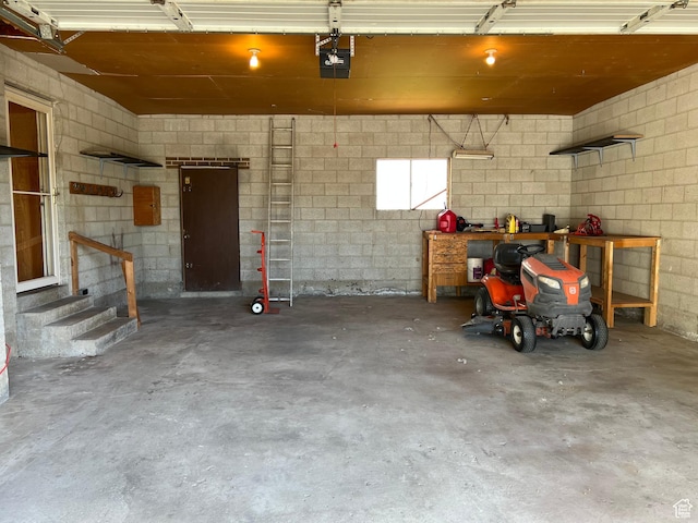 garage featuring a garage door opener and concrete block wall