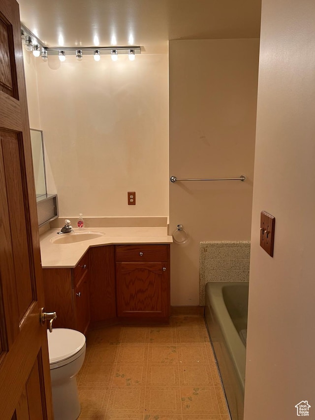 bathroom with vanity, toilet, and a tub