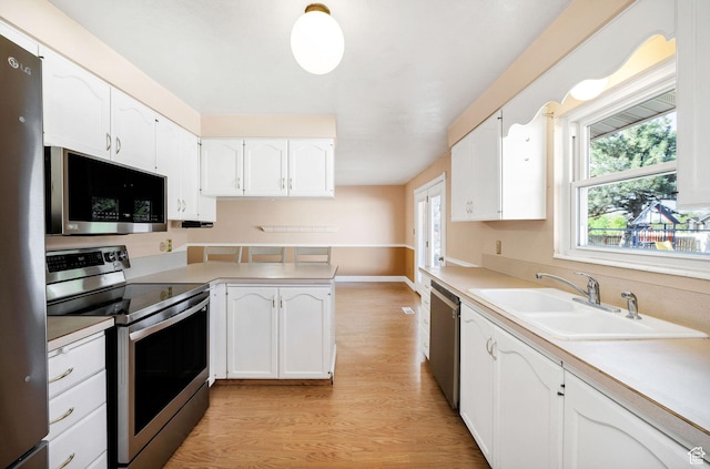 518 E Wendy Way S, Tremonton, UT 84337 - kitchen with stainless steel appliances, white cabinetry, a sink, and light wood-type flooring