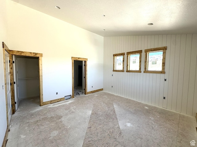 3042 S Chukar Dr, Garden City, UT 84028 - unfurnished bedroom with baseboards, a textured ceiling, lofted ceiling, and a spacious closet