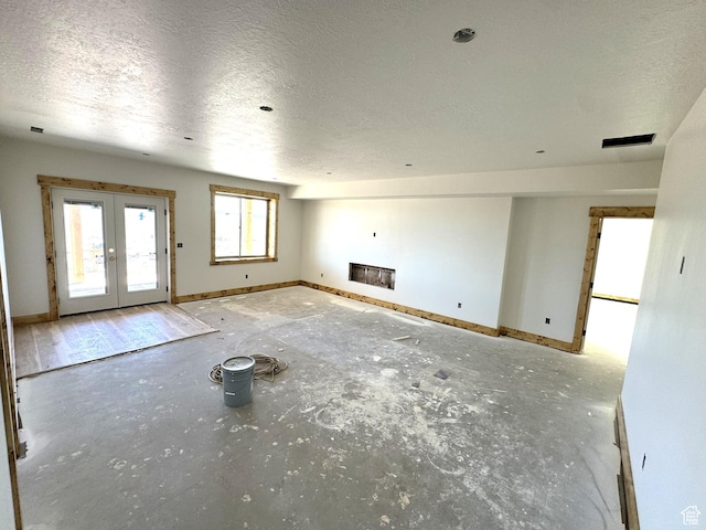 3042 S Chukar Dr, Garden City, UT 84028 - unfurnished living room featuring baseboards, french doors, and a textured ceiling