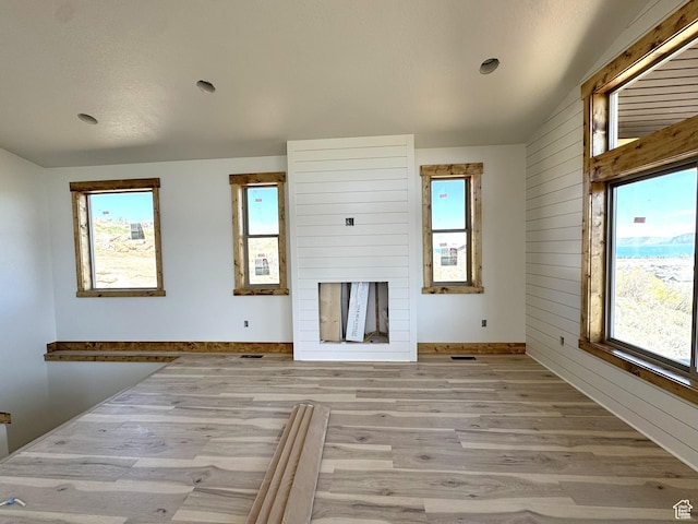 3042 S Chukar Dr, Garden City, UT 84028 - unfurnished living room featuring recessed lighting, wood walls, light wood finished floors, and a healthy amount of sunlight