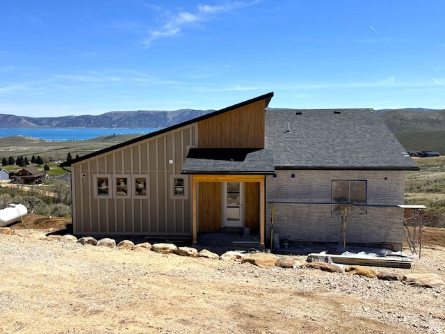3042 S Chukar Dr, Garden City, UT 84028 - view of front facade featuring a water and mountain view, a shingled roof, and board and batten siding