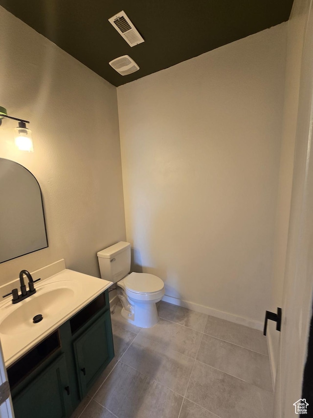 half bath featuring toilet, visible vents, baseboards, tile patterned flooring, and vanity
