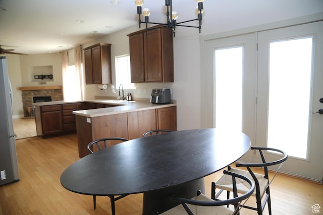 3596 W 2610 S, Syracuse, UT 84075 - kitchen featuring a peninsula, freestanding refrigerator, a chandelier, light wood-type flooring, and a sink