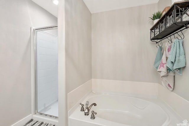 bathroom featuring a bath and a shower stall