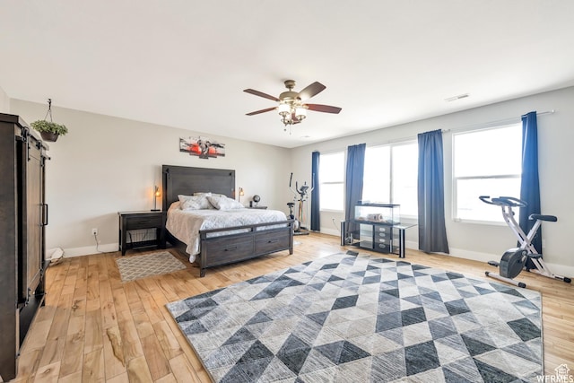 bedroom featuring baseboards, a ceiling fan, light wood-type flooring, and visible vents
