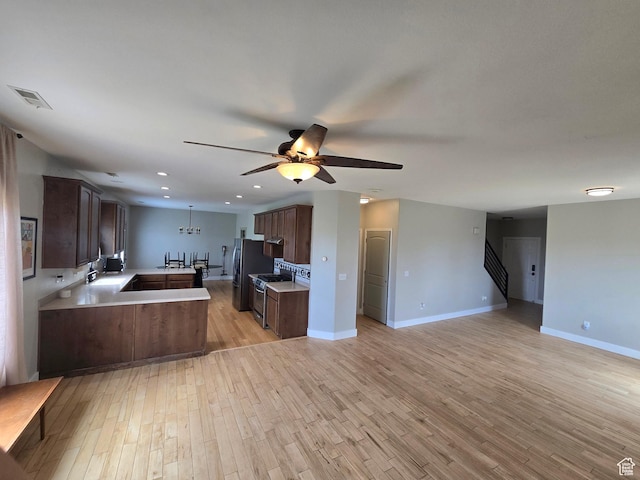 kitchen with stainless steel appliances, light wood-style flooring, a ceiling fan, and open floor plan