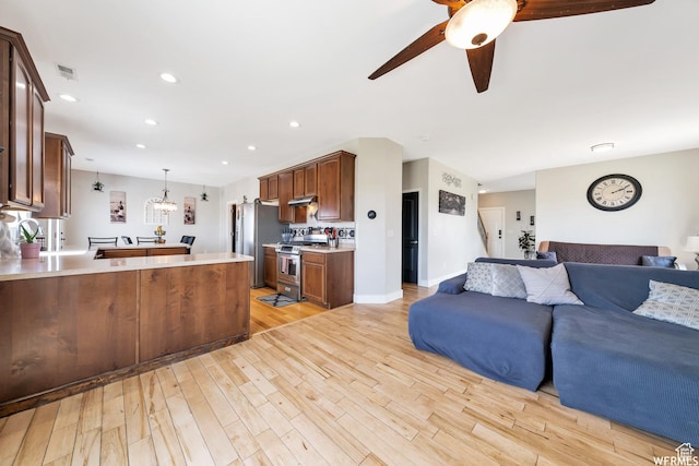 living room with a ceiling fan, visible vents, light wood-type flooring, baseboards, and recessed lighting
