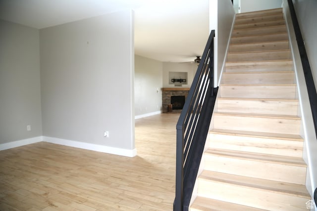 3596 W 2610 S, Syracuse, UT 84075 - stairway featuring baseboards, a fireplace, wood finished floors, and a ceiling fan