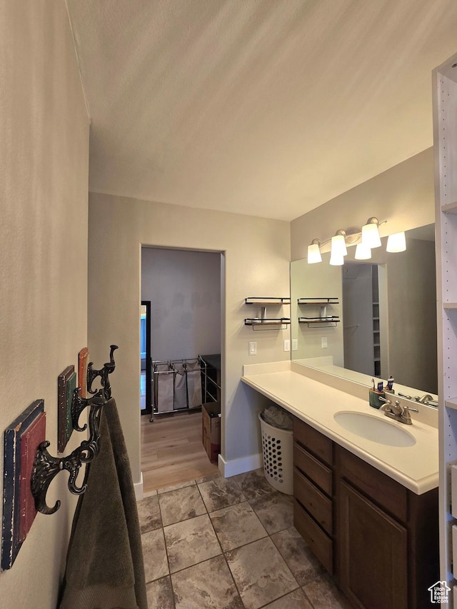 bathroom with vanity, baseboards, and tile patterned floors