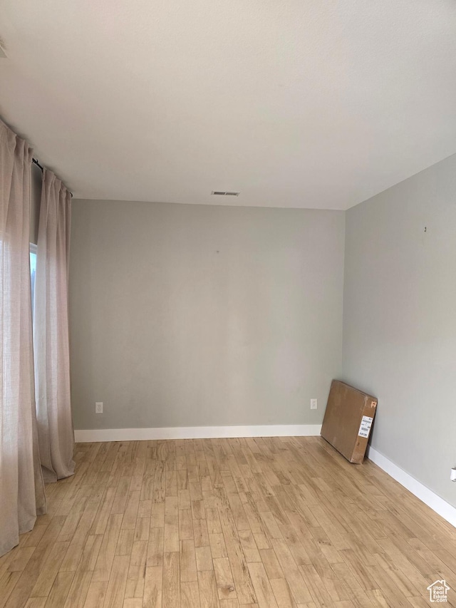 unfurnished room featuring light wood-style flooring, baseboards, and visible vents