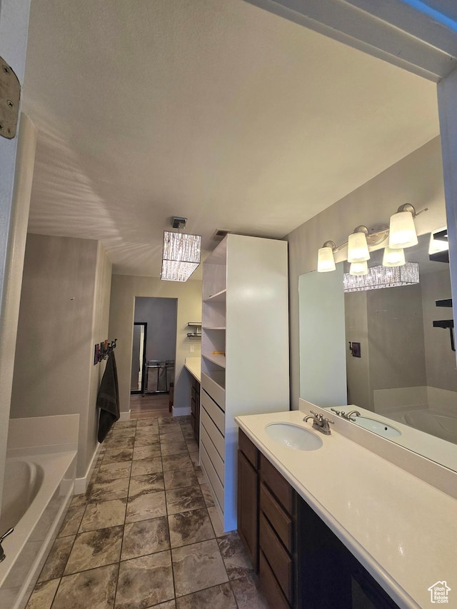 full bathroom with baseboards, a garden tub, and vanity