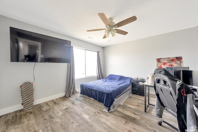 bedroom featuring baseboards, a ceiling fan, and wood finished floors