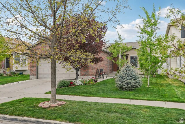 8564 S Laurel Oak Dr W, West Jordan, UT 84088 - obstructed view of property featuring driveway, a garage, a front lawn, and brick siding