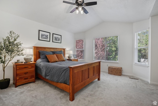 bedroom featuring light carpet, vaulted ceiling, baseboards, and ceiling fan