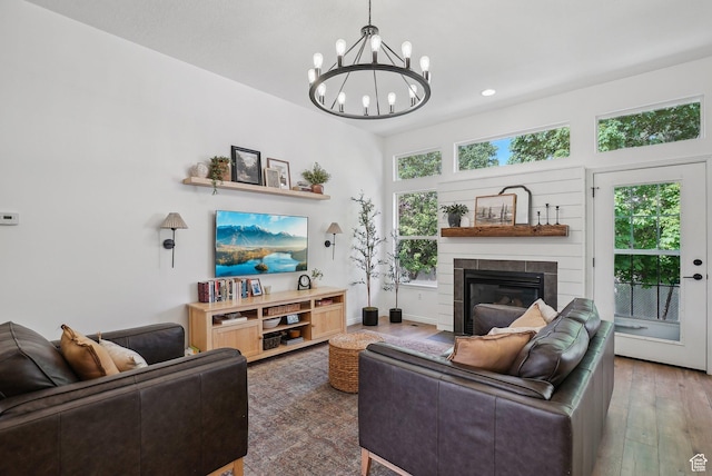 living area featuring a chandelier, a fireplace with flush hearth, wood finished floors, and recessed lighting