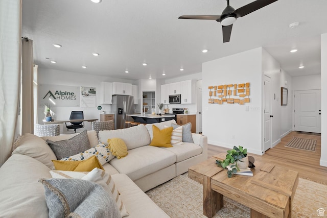 living room with recessed lighting, ceiling fan, baseboards, and light wood-type flooring