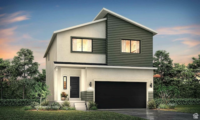 contemporary house with stucco siding, an attached garage, and driveway