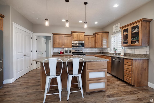 486 N 3500 W, Vernal, UT 84078 - kitchen with brown cabinets, decorative backsplash, appliances with stainless steel finishes, and a kitchen island