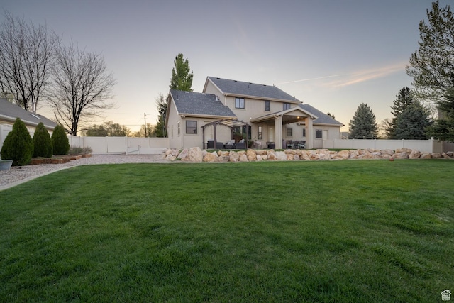 486 N 3500 W, Vernal, UT 84078 - back of property at dusk with a lawn, a fenced backyard, and stucco siding