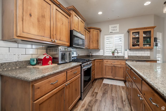 486 N 3500 W, Vernal, UT 84078 - kitchen with brown cabinets, stainless steel appliances, decorative backsplash, and wood finished floors