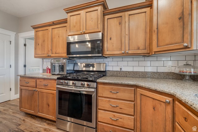 486 N 3500 W, Vernal, UT 84078 - kitchen with brown cabinets, appliances with stainless steel finishes, light wood finished floors, and tasteful backsplash