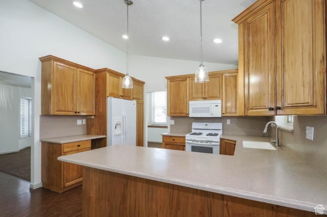 kitchen featuring a sink, light countertops, a peninsula, and white appliances