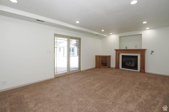 unfurnished living room featuring a fireplace, baseboards, carpet, and recessed lighting