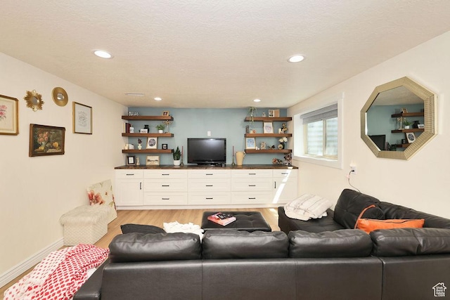 living room featuring recessed lighting, a textured ceiling, and light wood-style flooring