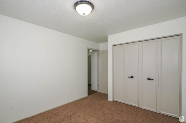 unfurnished bedroom with a closet, carpet flooring, and a textured ceiling