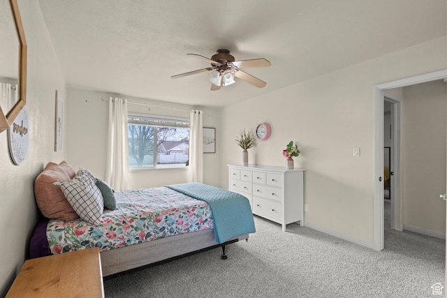 bedroom featuring baseboards, a ceiling fan, and light colored carpet