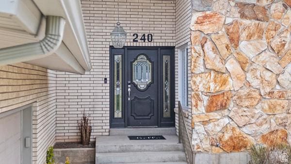 entrance to property featuring brick siding and stone siding