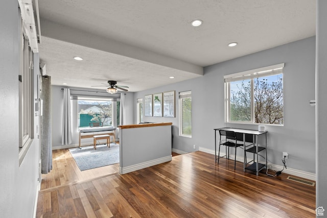 interior space featuring visible vents, hardwood / wood-style floors, baseboards, recessed lighting, and a textured ceiling