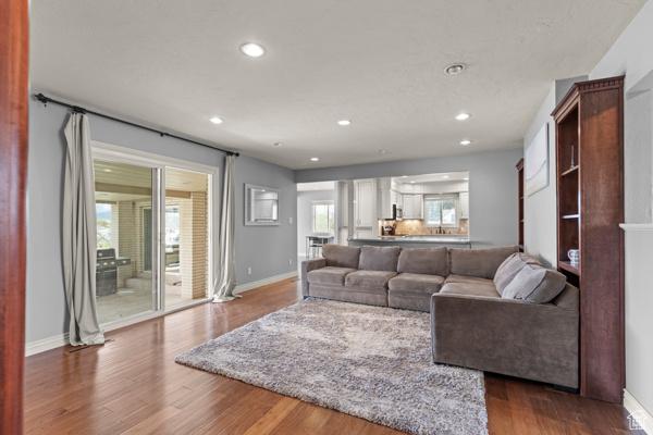 living area with baseboards, recessed lighting, and wood finished floors